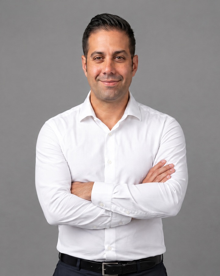 Rubén Requena sonriendo con los brazos cruzados, con camisa blanca